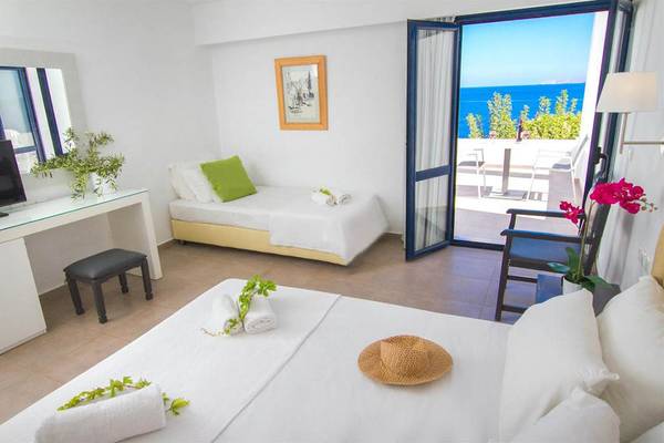 Ein modernes Hotelzimmer mit Meerblick, inklusive zwei Betten, Schreibtisch und Balkon.