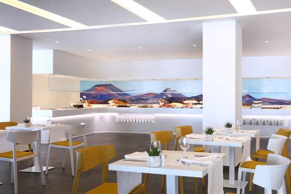 Innenansicht des Restaurants im Iberostar Selection Lanzarote Park mit modernen Möbeln und Berglandschaft im Hintergrund.