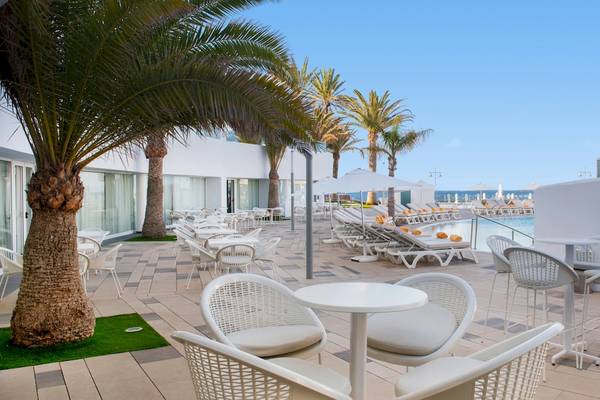 Außenbereich des Iberostar Selection Lanzarote Park Hotels mit Loungestühlen und Tischen neben dem Pool