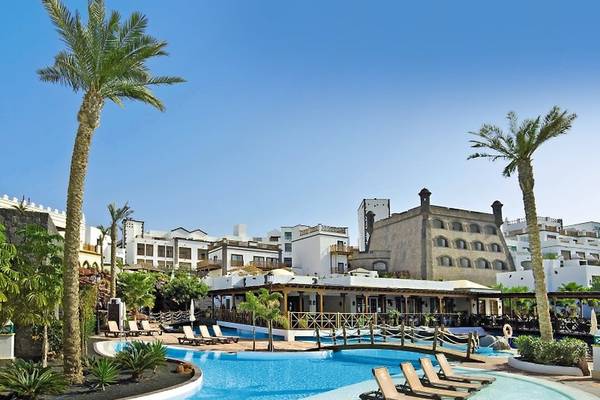 Außenbereich des Gran Castillo Tagoro Family & Fun Hotels mit Swimmingpool, Sonnenliegen und Palmen