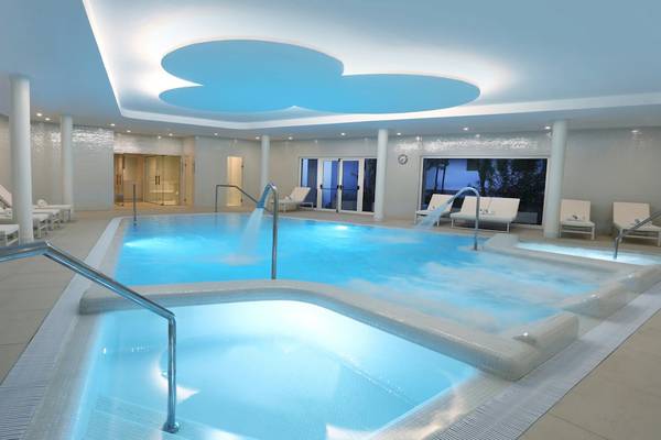 Indoor-Poolbereich des Iberostar Selection Lanzarote Park mit mehreren Liegestühlen und Wasserfällen.