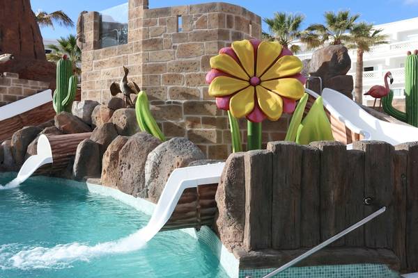 Poolbereich im Iberostar Selection Lanzarote Park mit Wasserrutschen und künstlichen Pflanzen.