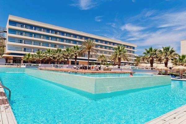 Außenpool des Blue Sea Beach Resorts mit Hotel im Hintergrund und Palmen.