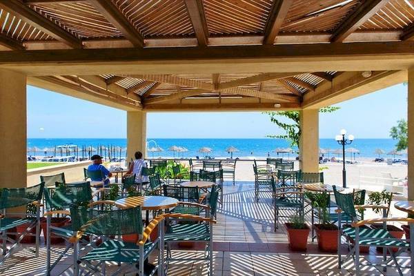 Terrasse des Blue Sea Beach Resorts mit Blick auf den Strand und das Meer.