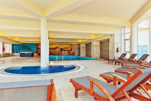 Innenpoolbereich des Blue Sea Beach Resorts mit Liegestühlen und einem kleinen Whirlpool.