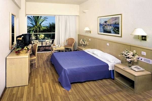 Zimmer im Blue Sea Beach Resort Hotel mit Balkon, Blumen, und Panoramablick.