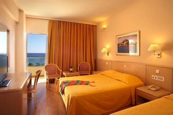 Hotelzimmer des Blue Sea Beach Resort mit Blick auf das Meer, zwei Betten, Schreibtisch und Fernseher.