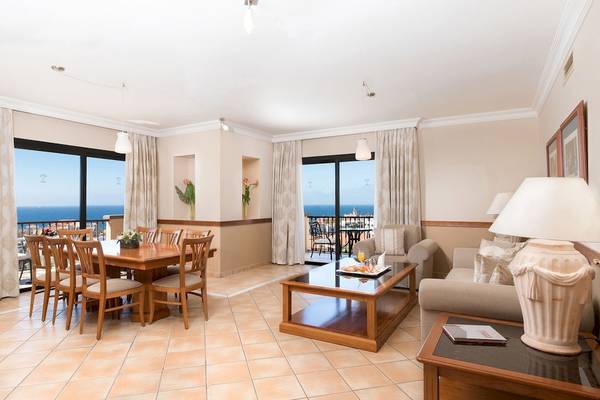 Wohnzimmer des GF Gran Costa Adeje Hotels mit Tisch, Sofa und Meerblick