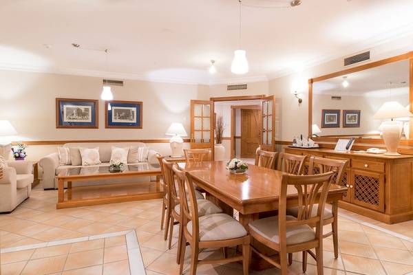 Speisezimmer im GF Gran Costa Adeje Hotel mit Esstisch, Stühlen und Dekor.