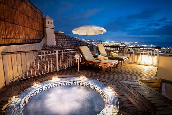 Hotelterrasse mit Jacuzzi und Blick auf die Stadt bei Nacht