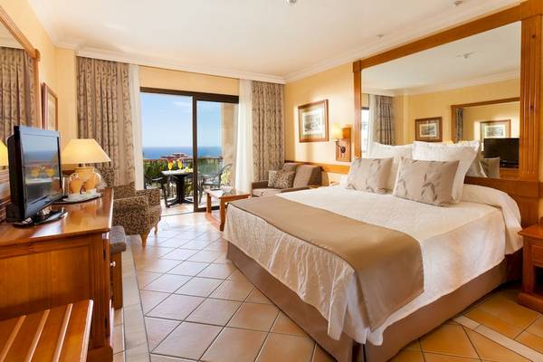 Hotelzimmer im GF Gran Costa Adeje mit Balkon, Panoramafenstern und Meerblick.
