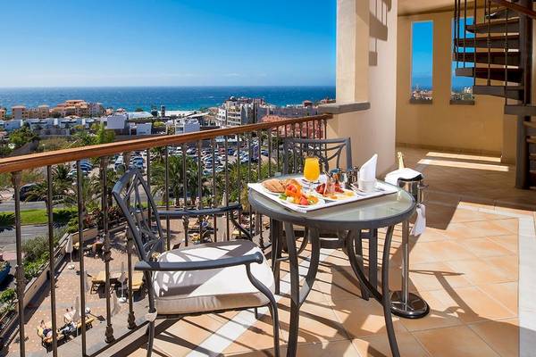 GF Gran Costa Adeje Balkon mit Frühstückstisch und Panoramablick auf das Meer und die Stadt.