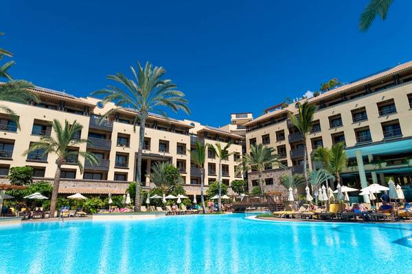 Außenansicht des GF Gran Costa Adeje Hotels mit Swimmingpool und Sonnenliegen