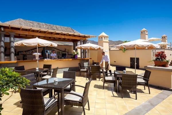 Terrasse des GF Gran Costa Adeje Hotels mit Tischen, Stühlen und Sonnenschirmen