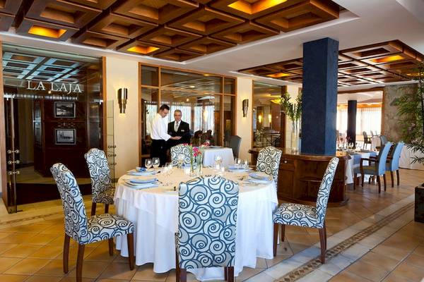 Innenansicht des Restaurants im GF Gran Costa Adeje Hotel mit Tisch und Stühlen