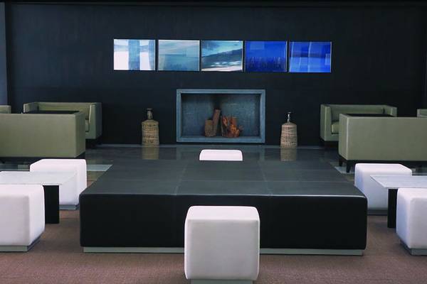 Lobby-Lounge-Bereich des Almyra Hotels mit modernen Möbeln, zentralem Tisch und Kunstwerken.