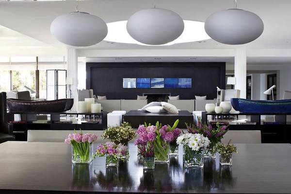 Wohnzimmer im Almyra Hotel mit Blumen auf dem Tisch und runden Lampen.
