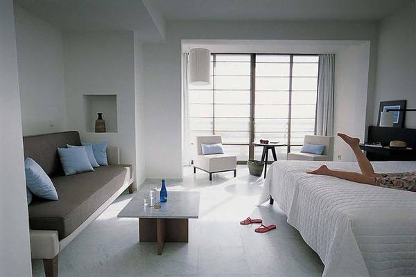 Ein modernes Schlafzimmer im Almyra Hotel mit einem Bett, einer Couch und einer Aussicht auf den Garten.