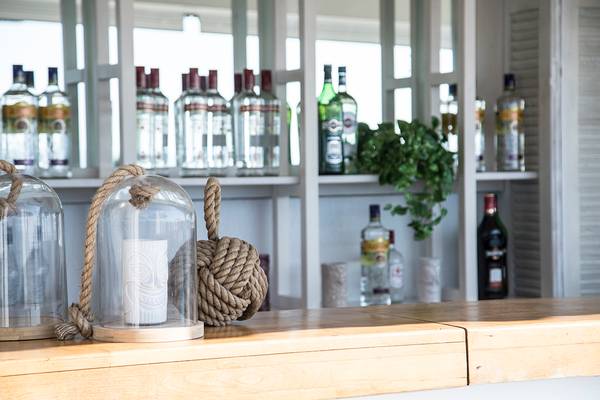 Cocktailbar-Dekoration im Sea Side Resort & Spa mit Flaschen und Glaslaternen.