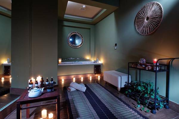 Innenraum des Sea Side Resort & Spa mit einem Whirlpool, Kerzen und einem Massagetisch.