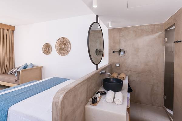Schlafzimmer im Sea Side Resort & Spa mit Bett, Waschbecken und Badezimmer