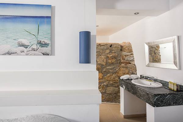 Badezimmer im Sea Side Resort & Spa mit Blick auf das Meer und einem Steinmauer.