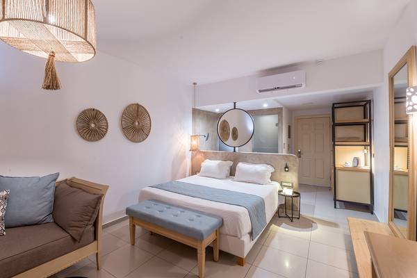 Schlafzimmer im Sea Side Resort & Spa mit Bett, Couch, Lampe und Deko-Elementen