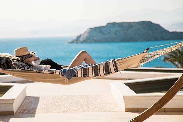 Gast im Sea Side Resort & Spa auf der Hängematte mit Blick auf das Meer und eine Insel.