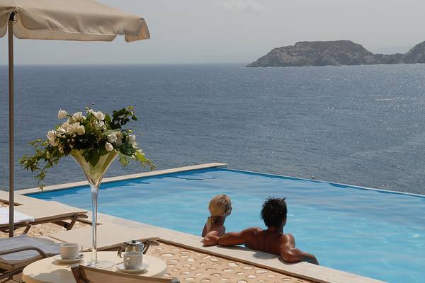 Ein Paar genießt einen Blick auf das Meer von ihrem Infinity-Pool im Sea Side Resort & Spa.