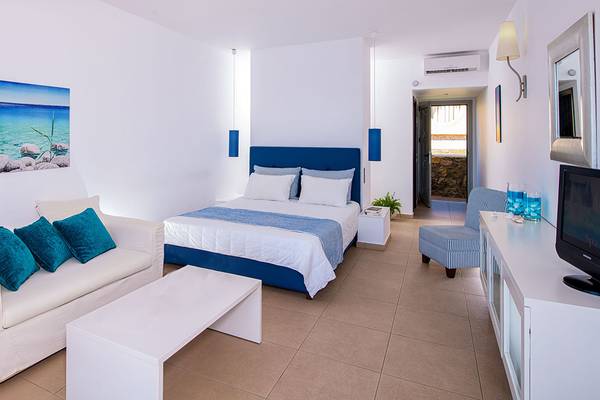 Schlafzimmer im Sea Side Resort & Spa mit Bett, Sofa, Fernseher und Fenster