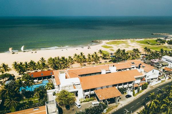 Luftaufnahme des Goldi Sands Hotels mit Pool und Meer im Hintergrund.