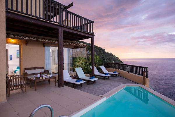 Terrasse mit Liegen und Swimmingpool mit Blick auf das Meer am Sea Side Resort & Spa