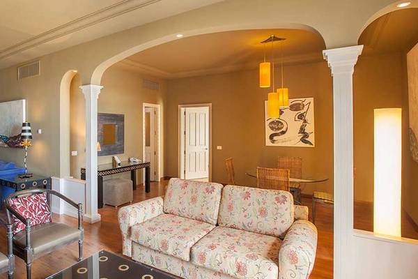 Wohnbereich im Lopesan Villa del Conde Resort & Thalasso mit Sofa, Sessel, Couch, Tisch und Wanddekoration
