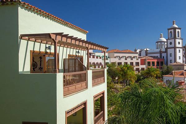 Aussicht auf das Lopesan Villa del Conde Resort & Thalasso mit Gebäuden und Palmen.
