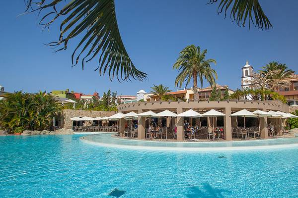 Außenpool des Lopesan Villa del Conde Resort mit umliegenden Gebäuden und Palmen