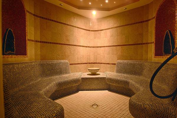 Innenansicht der Sauna im Lopesan Villa del Conde Resort & Thalasso mit gefliesten Wänden und Sitzbänken.