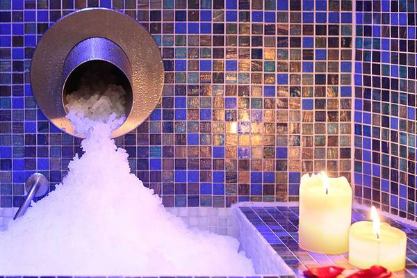 Spa-Badewanne im Lopesan Villa del Conde Resort mit Schnee und Kerzen.