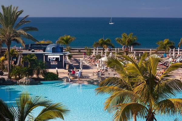 Luftaufnahme des Swimmingpools im Lopesan Villa del Conde Resort mit Blick auf das Meer und Palmen