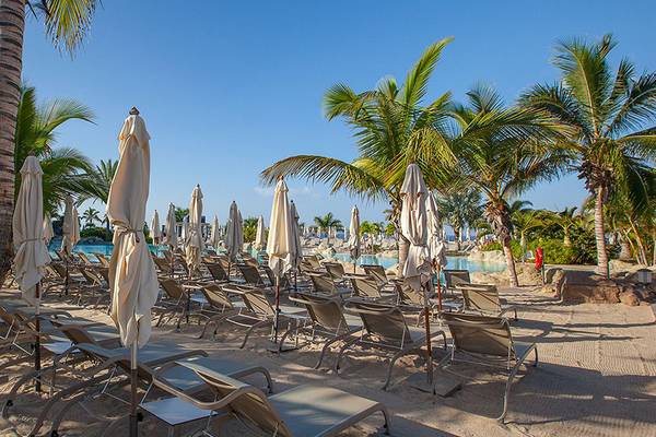 Poolbereich des Lopesan Villa del Conde Resorts mit Sonnenliegen und Palmen