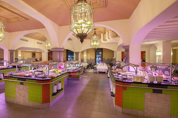 Buffetbereich im Lopesan Villa del Conde Resort mit bunten Wänden und vielen Speisen.