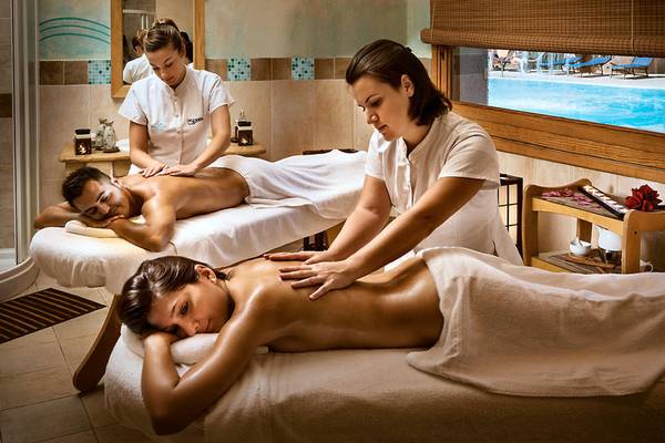 Massagebehandlung im Marinedda Hotel Thalasso & Spa mit Pool im Hintergrund.