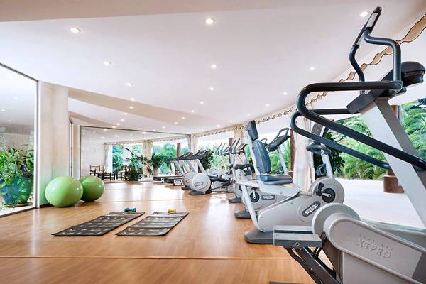 Fitnessstudio im Marinedda Hotel Thalasso & Spa mit Cardiogeräten und Yogamatten