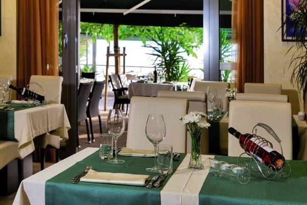Restauranttisch des Saudade Hotels mit grünem Tischtuch und Weinflaschen.