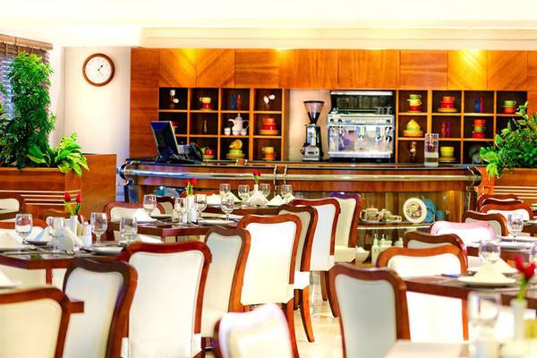 Innenansicht des Restaurants im Golden Sands Hotel Apartments mit gedeckten Tischen und Bar im Hintergrund.