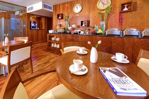 Frühstücksbereich im Golden Sands Hotel Apartments mit Holzmöbeln und Frühstücksbuffet.