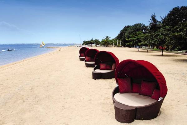 Strand mit roten Loungesesseln im Prama Sanur Beach Bali Hotel.