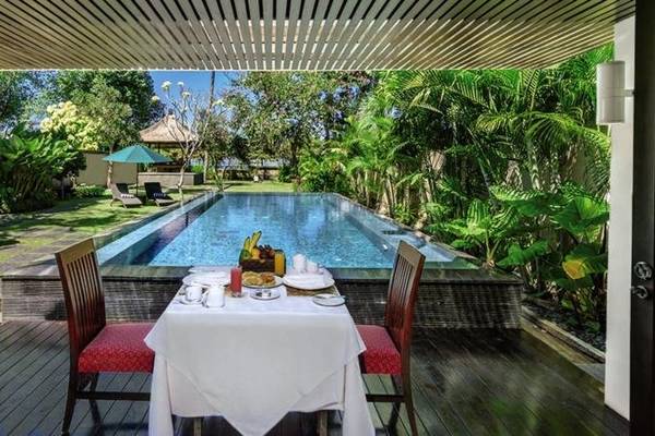 Außenesstisch am Pool im Prama Sanur Beach Bali Hotel mit Blick auf den Garten