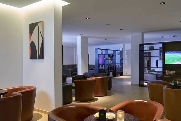 Loungebereich des Melia Dunas Beach Resort mit Fernseher und Lederstühlen.