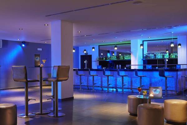 Bar im Melia Dunas Beach Resort & Spa mit blauer Beleuchtung und hochmoderner Einrichtung.