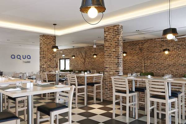 Innenansicht des Aqua Restaurants im Melia Dunas Beach Resort & Spa mit gemustertem Boden und Ziegelwänden.